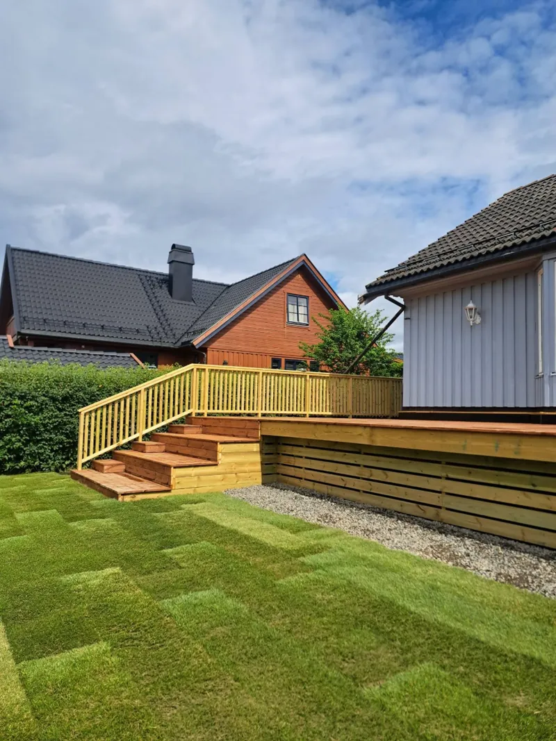 Ny terrasse med trapp og rekkverk, sett fra den nylagte ferdigplenen