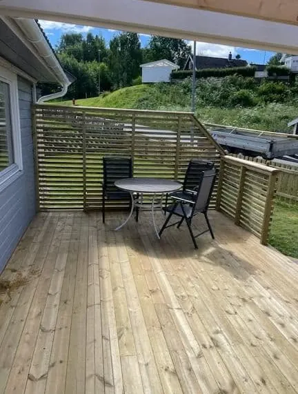 Terrasse med levegg i spiler, bord og stoler